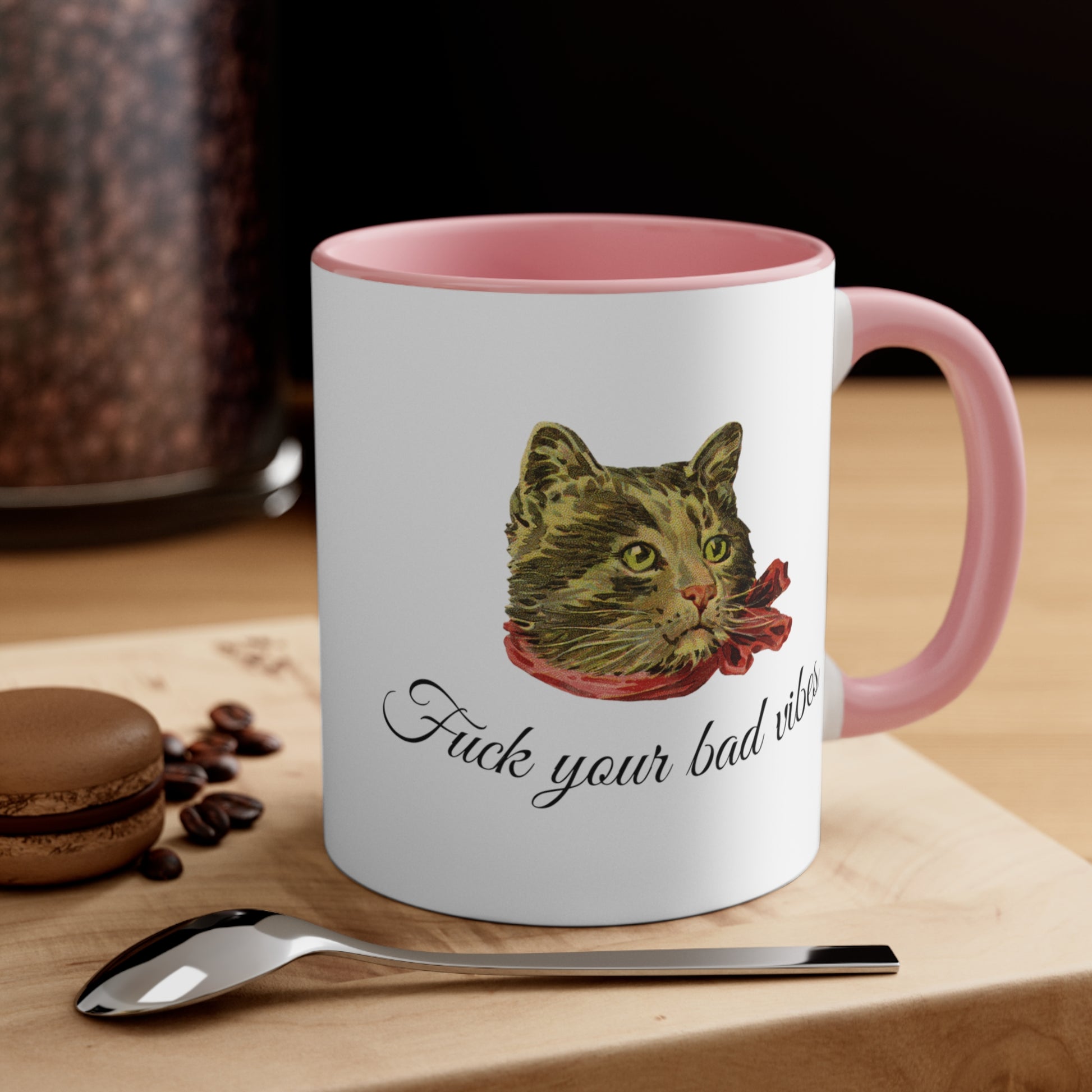 white and pink mug featuring the phrase "Fuck Your Bad Vibes" in elegant cursive beneath a charming vintage graphic of a stylish cat sporting a scarf