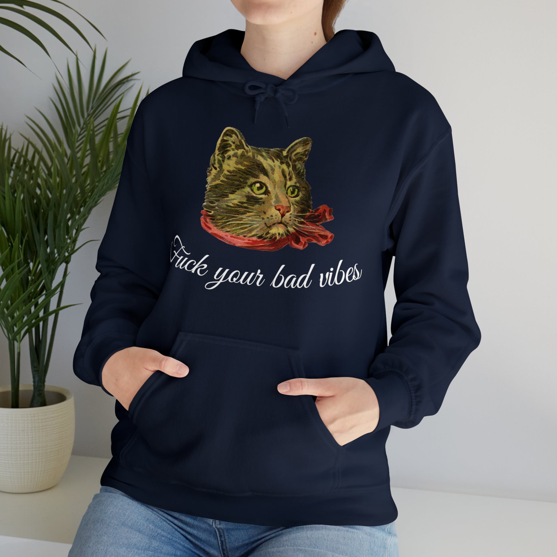 woman wearing navy blue hoodie featuring the phrase "Fuck Your Bad Vibes" in elegant cursive beneath a charming vintage graphic of a stylish cat sporting a scarf