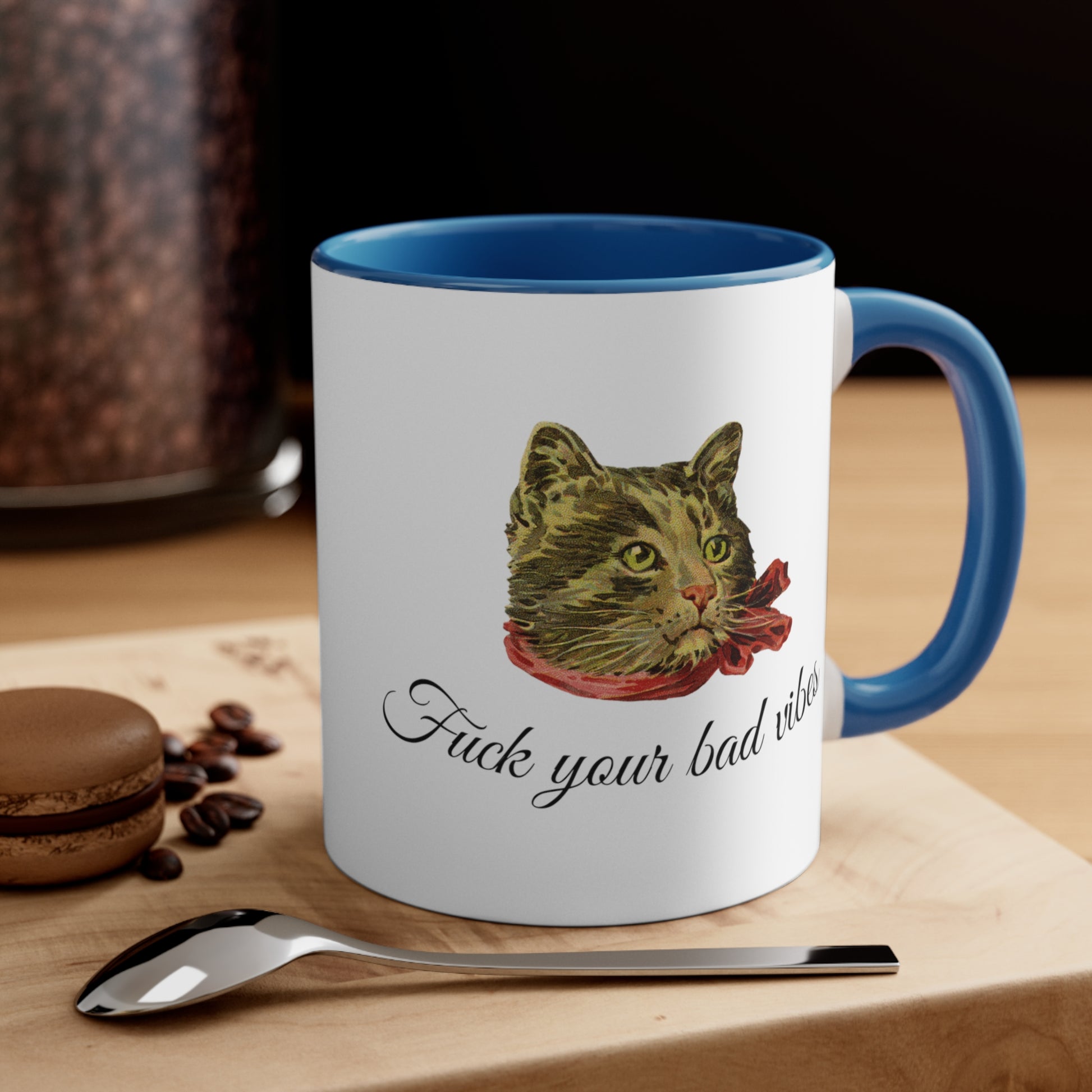 white and light blue mug featuring the phrase "Fuck Your Bad Vibes" in elegant cursive beneath a charming vintage graphic of a stylish cat sporting a scarf