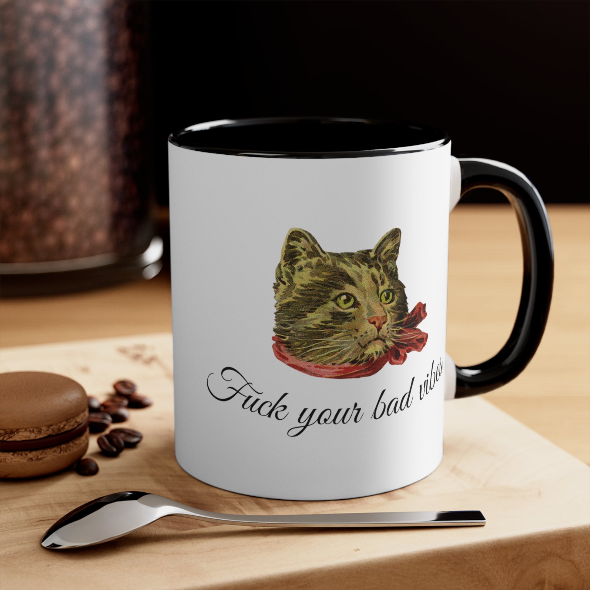 white and black mug featuring the phrase "Fuck Your Bad Vibes" in elegant cursive beneath a charming vintage graphic of a stylish cat sporting a scarf